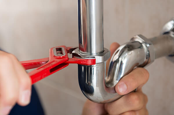 plumber fixing pipe with tool